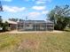Enclosed screened-in pool located in a spacious backyard with green grass and plenty of room to roam at 804 Pineland Ave, Venice, FL 34285