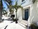 Charming coastal home featuring a vibrant blue door, white stucco, and beautiful palm trees at 813 Burlington N Ave, St Petersburg, FL 33701