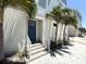 Coastal home featuring a vibrant blue door, white stucco, lush landscaping, and inviting curb appeal at 813 Burlington N Ave, St Petersburg, FL 33701