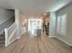 Open-concept living space with sleek gray flooring, island kitchen, and staircase to upper level at 813 Burlington N Ave, St Petersburg, FL 33701