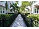 A pathway leading to townhomes, featuring a well-maintained walkway, black fence and lush landscaping at 813 Burlington N Ave, St Petersburg, FL 33701