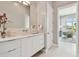 Bright bathroom featuring a long modern white vanity and countertop with decor and an adjacent office space at 90 Martinique Ave, Tampa, FL 33606