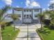 Beautiful two-story home with manicured lawn and palm trees, offering a luxurious waterfront living experience at 90 Martinique Ave, Tampa, FL 33606