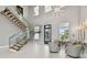 Bright living room with soaring ceilings, stylish light fixture, and a staircase with glass railing at 90 Martinique Ave, Tampa, FL 33606