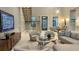 Grand living room with a floating staircase, statement chandelier, and comfortable seating at 90 Martinique Ave, Tampa, FL 33606