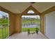 Screened balcony showcasing a serene view of the lake and surrounding greenery at 9481 Highland Oak Dr # 1206, Tampa, FL 33647