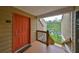 Condo entrance features a cheerful orange door and a glimpse of a serene lake view at 9481 Highland Oak Dr # 1206, Tampa, FL 33647