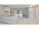 Open concept kitchen with white cabinets, breakfast bar, and seamless flow into the living room at 9481 Highland Oak Dr # 1206, Tampa, FL 33647