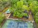 Aerial view of tennis courts, picnic shelter, and playground area covered in mulch, surrounded by tall trees at 9481 Highland Oak Dr # 1206, Tampa, FL 33647
