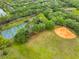 Aerial view of tennis and baseball fields surrounded by lush greenery, mature trees, and a winding body of water at 9481 Highland Oak Dr # 1206, Tampa, FL 33647