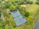 Aerial view of tennis courts surrounded by lush greenery and trees, with a park and baseball field nearby at 9481 Highland Oak Dr # 1206, Tampa, FL 33647