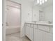 Modern bathroom features double sinks, white cabinetry, and a subway-tiled shower/tub combination at 10418 Cross River Trl, Parrish, FL 34219