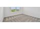 Cozy bedroom with neutral walls and carpeting; window provides natural light and view of the surroundings at 10418 Cross River Trl, Parrish, FL 34219