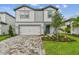 Two-story home with white and gray accents, well-kept lawn, and a two-car garage at 10418 Cross River Trl, Parrish, FL 34219
