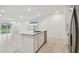 Open kitchen with stainless steel dishwasher and sink in large island and tile flooring at 10418 Cross River Trl, Parrish, FL 34219
