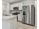 Close up of kitchen with stainless steel refrigerator and gas range with microwave above at 10418 Cross River Trl, Parrish, FL 34219