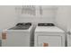 Bright laundry room featuring a full-size washer and dryer, as well as an overhead storage shelf at 10418 Cross River Trl, Parrish, FL 34219