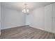 Minimalist dining area with wood floors, a chandelier, and a pass-through to the kitchen at 10906 Keys Gate Dr, Riverview, FL 33579