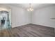 Minimalist dining area with wood floors, a chandelier, and open access to other rooms at 10906 Keys Gate Dr, Riverview, FL 33579