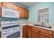 Bright kitchen features wood cabinets and white appliances at 10906 Keys Gate Dr, Riverview, FL 33579