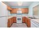 Bright kitchen features wood cabinets, white appliances, light countertops and gray wood flooring at 10906 Keys Gate Dr, Riverview, FL 33579