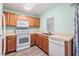 Bright kitchen features wood cabinets, white appliances, light countertops and gray wood flooring at 10906 Keys Gate Dr, Riverview, FL 33579