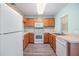 Bright kitchen features wooden cabinets, white appliances, and a window for natural light at 10906 Keys Gate Dr, Riverview, FL 33579