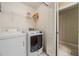 Well-equipped laundry room with modern washer, dryer, and convenient shelving for storage at 10906 Keys Gate Dr, Riverview, FL 33579