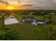 Scenic aerial view of the estate, featuring the horse on the lawn, home, barns, and riding arena at 11602 Innfields Dr, Odessa, FL 33556