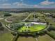 Expansive aerial view of a picturesque farm with lush greenery, horse track, and modern equestrian facilities at 11602 Innfields Dr, Odessa, FL 33556
