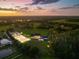 Panoramic aerial shot of the equestrian estate at sunset, featuring the home, barns, and arena at 11602 Innfields Dr, Odessa, FL 33556