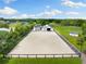Aerial view of the equestrian property with a sand training ground and white fencing at 11602 Innfields Dr, Odessa, FL 33556