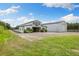 Exterior of the white barn featuring lush green grass and an expansive driveway at 11602 Innfields Dr, Odessa, FL 33556