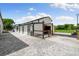 Bright white barn with horse stalls and an open-air run-in, offering ample space and convenience at 11602 Innfields Dr, Odessa, FL 33556