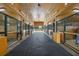 Barn interior featuring wooden stall fronts, fans, brick flooring, and natural light at 11602 Innfields Dr, Odessa, FL 33556