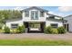 White barn with a green roof featuring a covered drive-through and adjacent landscaping at 11602 Innfields Dr, Odessa, FL 33556