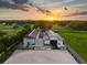 Aerial view of a charming barn with a beautiful sunset backdrop. Shows property landscape at 11602 Innfields Dr, Odessa, FL 33556