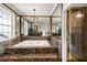 Bathroom with marble floors, a soaking tub, chandelier, and shower adds to the appeal of the house at 11602 Innfields Dr, Odessa, FL 33556