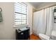 Well-lit bathroom showcases a shower, toilet, window, and convenient storage, offering a tidy layout at 11602 Innfields Dr, Odessa, FL 33556