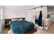 Bright bedroom with a barn door and a view of the bathroom in the background at 11602 Innfields Dr, Odessa, FL 33556