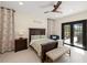 Comfortable bedroom featuring a ceiling fan and sliding glass door to outdoor patio at 11602 Innfields Dr, Odessa, FL 33556