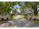 Inviting driveway leading to a modern farmhouse with mature trees and meticulously maintained landscaping at 11602 Innfields Dr, Odessa, FL 33556