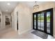 Bright entryway with modern lighting fixture, black framed windows and doorway overlooking lush landscaping at 11602 Innfields Dr, Odessa, FL 33556