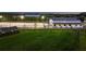 Well-maintained equestrian barn and paddock with lush lawns, mature trees, and black fencing at dusk at 11602 Innfields Dr, Odessa, FL 33556
