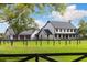 Stunning two-story farmhouse-style home with a three-car garage and lush green lawn at 11602 Innfields Dr, Odessa, FL 33556