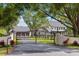 Stunning farmhouse featuring black iron gates, mature trees, well manicured landscaping, and verdant green lawns at 11602 Innfields Dr, Odessa, FL 33556