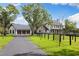 Modern farmhouse featuring a three-car garage, black accents, and lush green lawns at 11602 Innfields Dr, Odessa, FL 33556