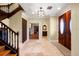 View of the foyer with tile flooring, an elegant wooden door, and stairs leading to the upper level at 11602 Innfields Dr, Odessa, FL 33556