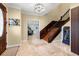Elegant foyer showcases a wooden staircase, tiled floor, and stylish lighting, creating a welcoming entrance at 11602 Innfields Dr, Odessa, FL 33556