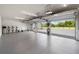 Spacious garage with overhead lighting and multiple garage doors with a view of the outdoors at 11602 Innfields Dr, Odessa, FL 33556